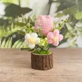 Handgestrickte rosa Tulpe im Topf mit kleinen Blumen und einem natürlichen Holzsockel - Rosa Dicke Tulpe