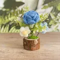 Handgehäkelte blaue Rose und Blumen in einem rustikalen Sockel aus natürlichem Echtholz - Rosenblau