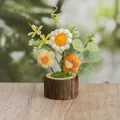 Gehäkelte Sonnenblume im Topf mit weißen und orangen Blumen auf einem Holzsockel - Gelbe Gänseblümchen Stil
