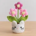 Handmade crochet cat planter with pink knitted flowers and green leaves on wooden desk - White Cat Pot Base / Puff Flower Pink