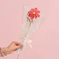 Handmade pink knitted rose flower in gift wrapping with a white LOVE IS ETERNAL ribbon - Cosmos Carmine