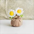 Handgehäkelte Gänseblümchen im Topf mit braunem Bodenbeutel und kleiner Schleife - Doppelkopf weißes Gänseblümchen-Stil