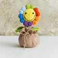 Handgefertigte gehäkelte Regenbogen-Sonnenblume im Jutesack mit lächelndem Gesicht - Bunte Sonnenblume Stil