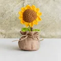 Handgehäkelte Sonnenblume im Topf mit gelben Blüten in einer rustikalen Jutetasche - Sonnenblume Stil