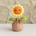 Handgefertigte Häkel-Sonnenblume im Topf mit gelben Blüten und niedlichem Smiley-Gesicht - Smiley Sonnenblume Stil