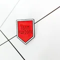 Close-up of a shield-shaped red enamel pin with TEAM AWESOME text for jackets - Red Shield (XZ0755) / Red (XZ0755)