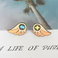 Pair of retro game-style orange wing enamel pins on a decorative aesthetic display card - Wing Shape Enamel Brooches (XZ1150)