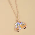 Close-up of golden necklace with colorful enamel camper van and mountain pendant - Camping Van Landscape Style (XL3407)