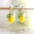 Yellow lemon drop earrings with green leaf and white flower details on gold hooks - Lemon Dangle Studs
