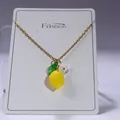 Detail of yellow lemon pendant necklace with green leaf and small white flower accents - Lemon Flower Necklace