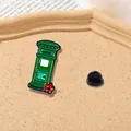 Close-up of vintage green mailbox enamel pin with floral detail and black rubber back clasp - Green Postbox Style (CZ0138)