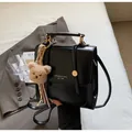 Schwarze Retro-Umhängetasche mit goldener Aufschrift und braunem Plüschbär-Anhänger - Mit Anhänger / Schwarz