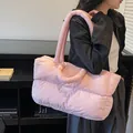Pink quilted puffer tote bag with large capacity and dual straps shown on a model - Pink