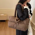 Dark brown quilted puffer tote bag shown on a model for a stylish daily commute look - Coffee