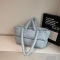 Light blue quilted down tote bag with a soft padded texture and dual handle design - Blue