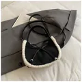 Black dumpling bag with white faux fur trim and bow detail in a casual setting - Black Without Charm