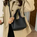 Minimalistische schwarze Leder-Eimertasche mit Lychee-Struktur und süßem Teddybär-Anhänger - 2-in-1 Taschen-Set / Ohne Anhänger / Schwarz / Hintergrundverletzung-Apple