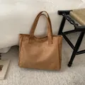 Bolso tote minimalista de ante marrón con asas dobles y logotipo redondo grabado - Marrón