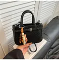 Schwarze Vintage Handtasche mit Webstruktur, Boho-Anhänger und Schultergurt - Schwarz