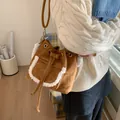 Brown faux suede bucket bag with white faux fur trim and adjustable crossbody strap - Brown