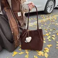 Dark brown faux suede tote bag with heart charm and slim straps for winter season - With Pendant / Coffee