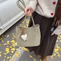 Large khaki suede tote bag with plush heart charm and bow detail in autumn setting - With Pendant / Green