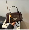 Dunkelbraune Handtasche aus Ölwachsleder mit Holzperlenquaste und silbernem Drehverschluss - Braun