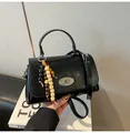 Glänzende schwarze quadratische Handtasche aus Leder mit Metalldrehverschluss und Perlen - Schwarz