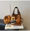 Brown litchi leather bucket bag with teddy charm and brown drawstring inner pouch - With Pendant / Brown with Pendant