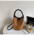 Brown frosted bucket bag with black dual handles and slender shoulder strap on white desk - No Pendant / Brown