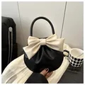 Elegante bolso de mano redondo negro con un gran lazo blanco crema y un diseño plisado - Negro