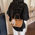 Borsa a tracolla vintage marrone in ecopelle con ciondolo a forma di coniglio su modella - Marrone