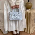 Borsa a mano a pieghe blu chiaro con fibbia argentata ed etichetta alla moda - Blu