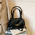 Bolso tote de cuero negro con asas superiores en un entorno de viaje profesional - Negro