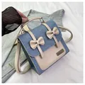Mini mochila de denim azul y cuero crema con detalles de lazos y placa metálica - Azul claro