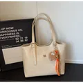 Creamy white leather tote bag with gold logo and brown plush charm accessory - With Pendant / Off White
