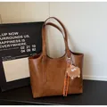 Brown vintage tote bag with metal logo and cute plush monster charm accessory - With Pendant / Yellow Brown