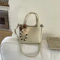 Creamy beige bucket bag in lychee leather featuring a cute bear charm with bow - With Pendant / White