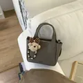 Grey pebbled leather bucket bag with top handles and cute teddy bear charm - With Pendant / Gray