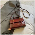 Elegante burgunderrote glänzende Kuriertasche mit goldener Hardware und Tragegriff - Ohne Anhänger / Rot