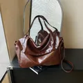 Deep brown oil wax leather tote bag for women featuring a glossy texture and silver buckle - Red