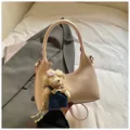 Elegant beige half-moon shoulder bag with a cute bear charm and long crossbody strap - Pink With Pendant