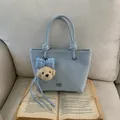 Light blue faux leather tote bag with plush puppy charm and blue checkered bow decor - Light Blue