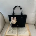 Black tote bag with COIN 2DN print, featuring a plush dog charm and rope handles - Black