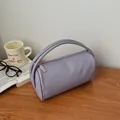 Chic lilac cylinder tote bag in lychee texture leather on a wooden desk setting - Purple