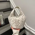 Beige corduroy tote bag with heart and rabbit prints held by a model on steps - Corduroy Style / White (Bear & Heart Pattern)