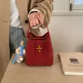 Borsa a secchiello rossa trama litchi con chiusura a scatto e ciondolo a orsetto - Senza Ciondolo / Rosso