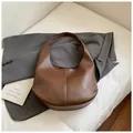 Minimalistische Hobo-Schultertasche aus karamellbraunem Leder in Retro-Halbmondform - Kaffeebraun
