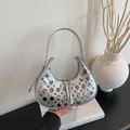 Silver crescent hobo bag with metallic rivets and slim shoulder strap in a minimalist setting - Silver