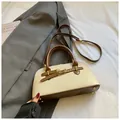 Close-up of minimalist square bag with beige canvas and brown leather stitching details - No Pendant / Off White